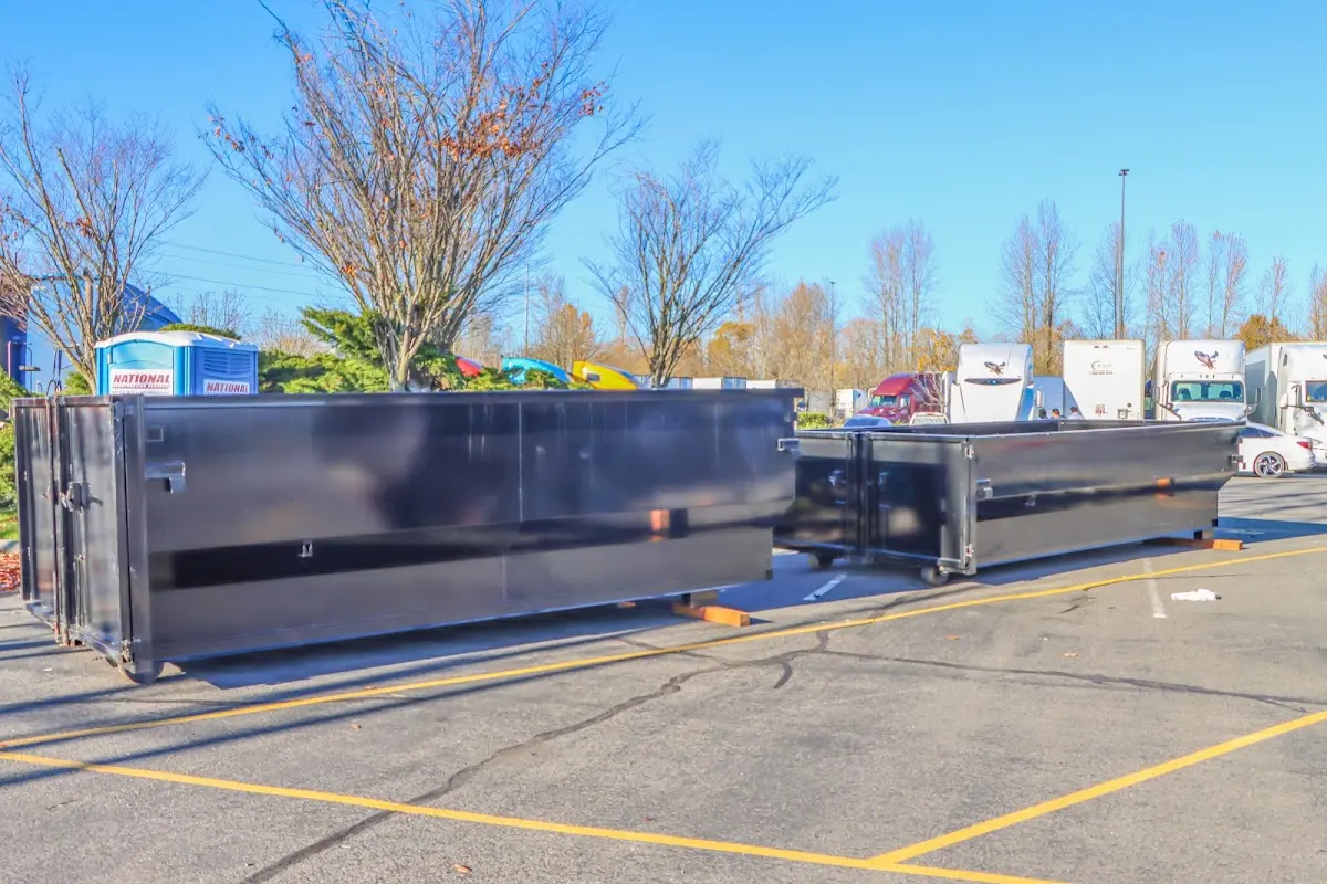 Professional dumpster rental service with roll-off container on residential driveway in Half Moon Bay